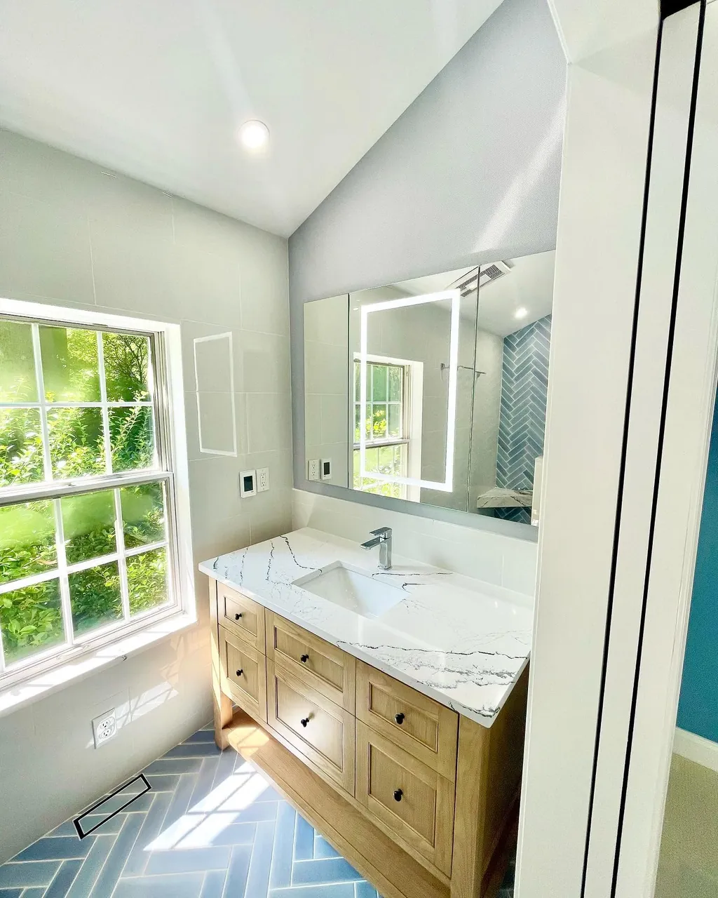 Bathroom remodel with custom vanity and blue tile floor by Delpa Builders
