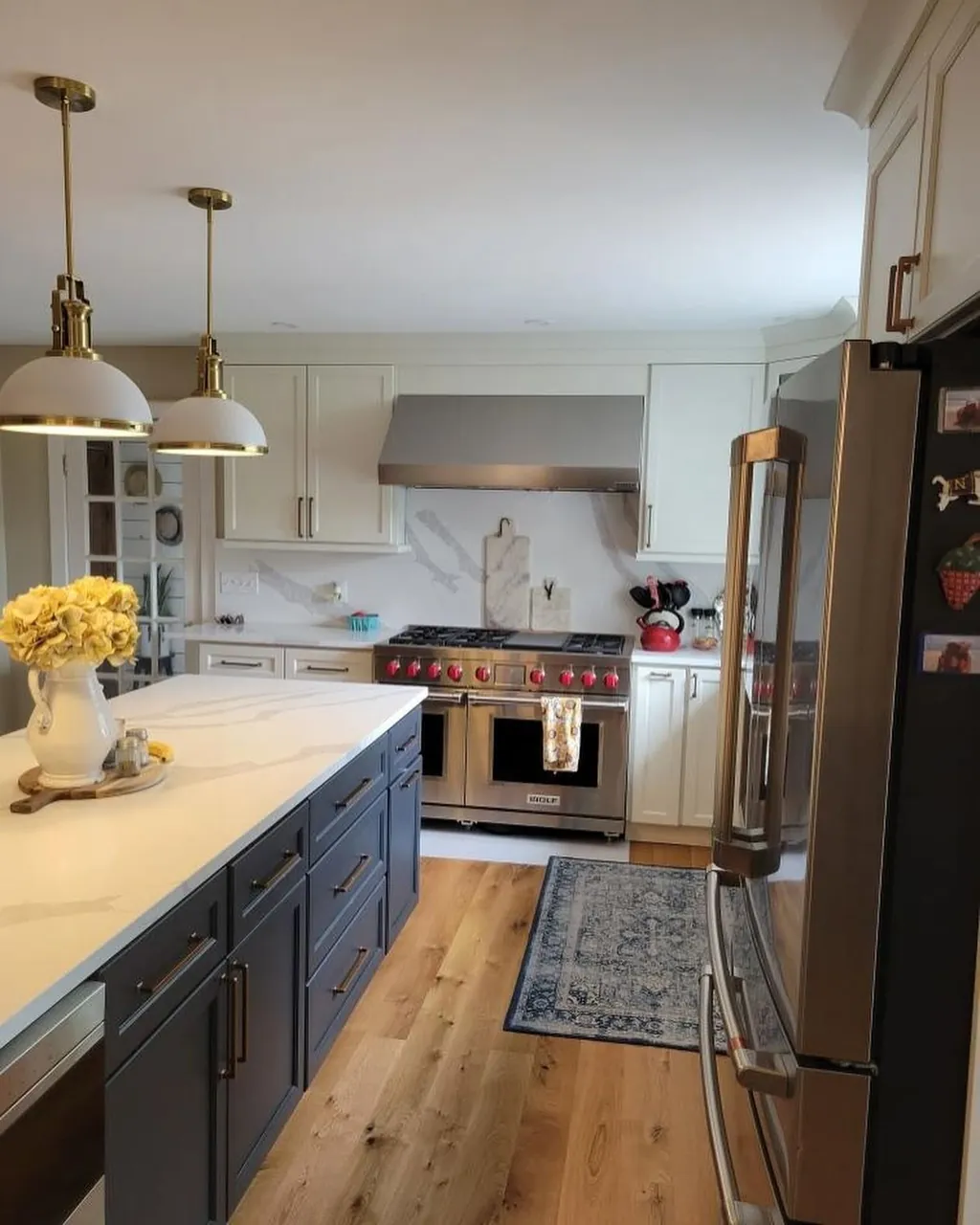 Kitchen remodel with slate blue island and brass pendants by Delpa Builders