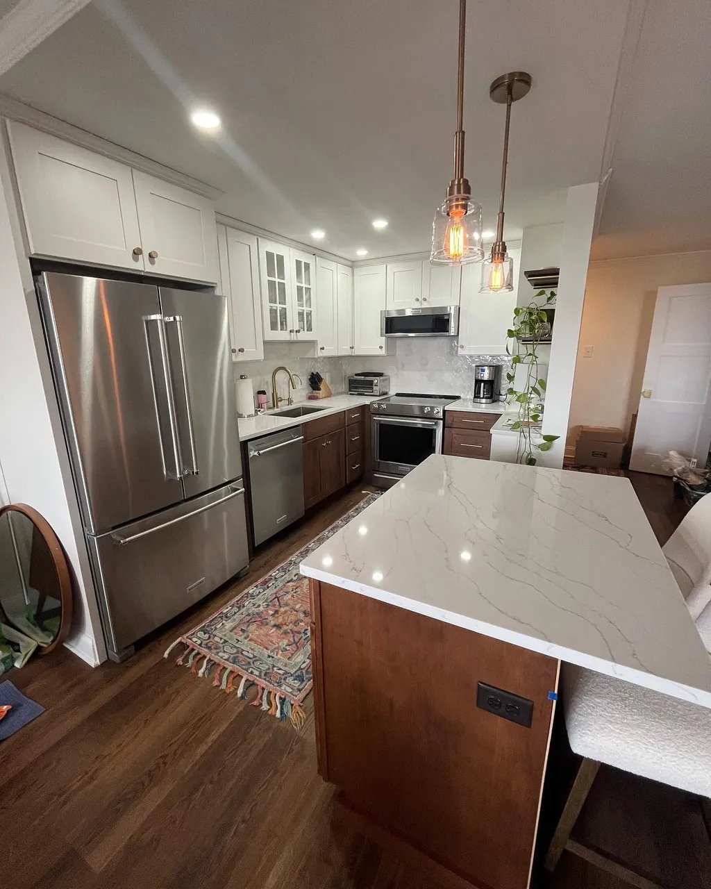 Kitchen remodel with wood cabinetry, white island and stainless appliances